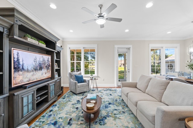 living room with ornamental molding, a healthy amount of sunlight, wood-type flooring, and ceiling fan