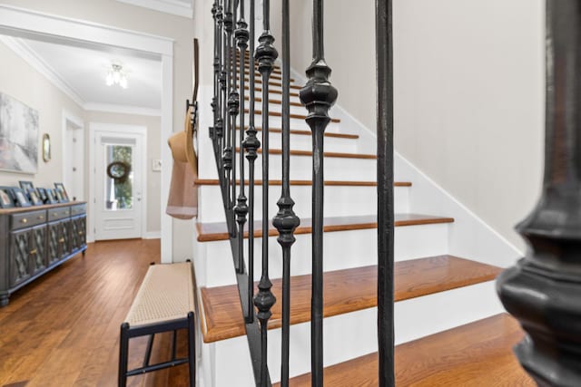 stairs with crown molding and hardwood / wood-style flooring