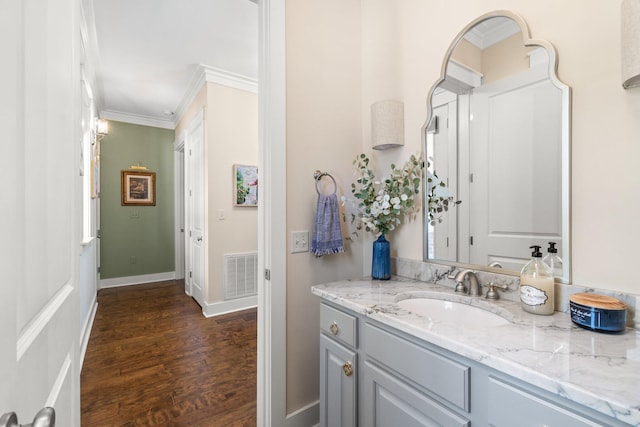 bathroom featuring vanity, crown molding, and wood-type flooring