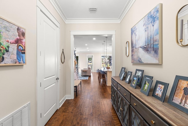 hallway with dark wood-type flooring and ornamental molding