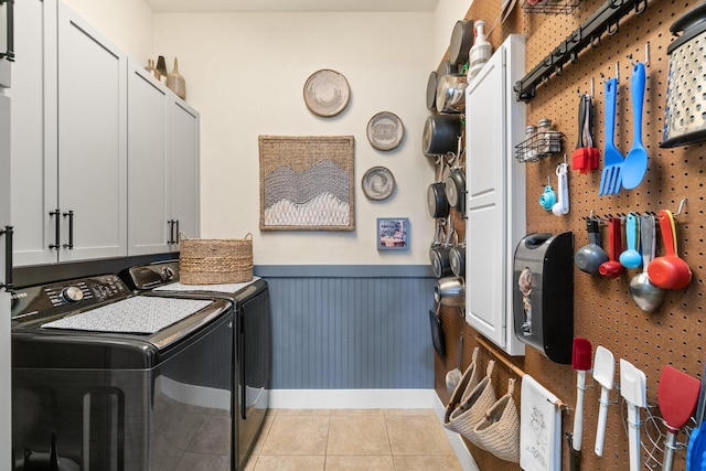 laundry room featuring a workshop area, separate washer and dryer, and light tile patterned floors