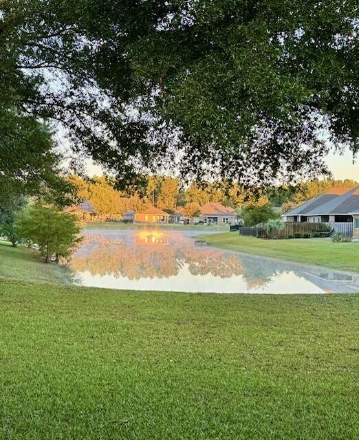 view of home's community featuring a water view and a yard