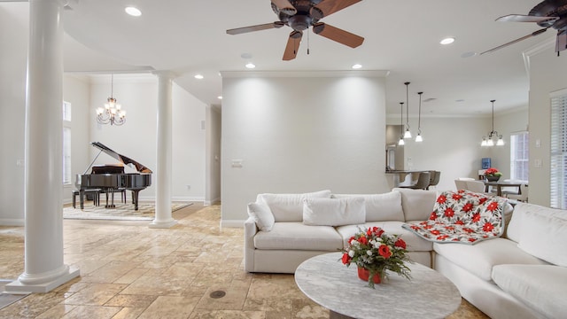 living room featuring decorative columns, crown molding, and ceiling fan with notable chandelier