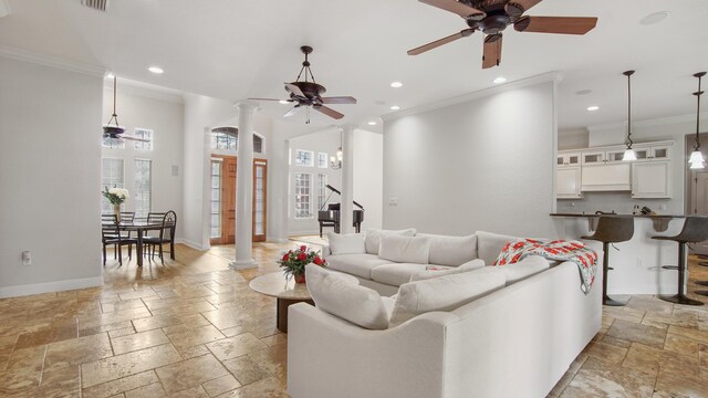 living room featuring ornate columns, ceiling fan, and ornamental molding