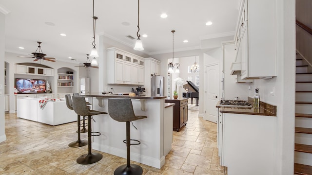 kitchen featuring white cabinetry, a center island, stainless steel appliances, and decorative light fixtures