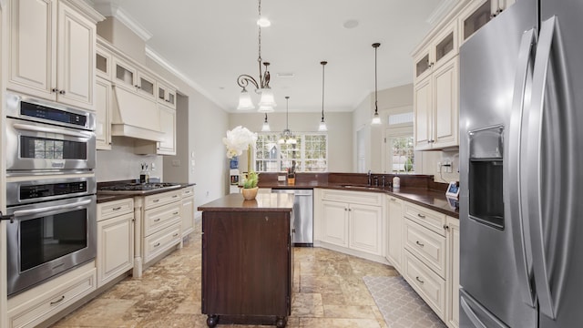 kitchen featuring sink, ornamental molding, appliances with stainless steel finishes, decorative light fixtures, and kitchen peninsula