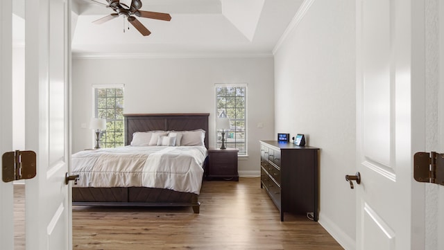 bedroom featuring multiple windows, ceiling fan, hardwood / wood-style floors, and ornamental molding