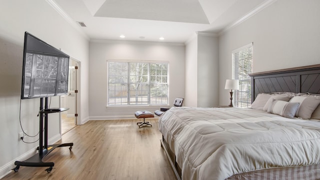 bedroom with multiple windows, ornamental molding, and light wood-type flooring