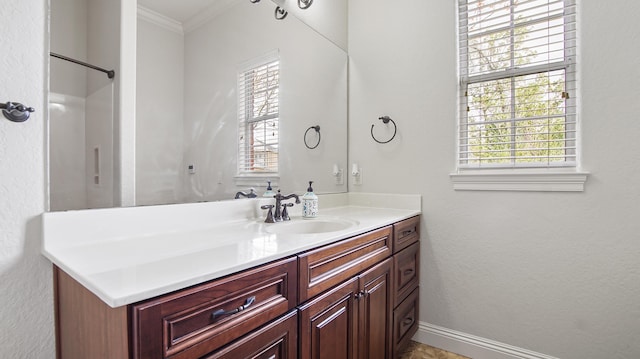 bathroom featuring vanity, a healthy amount of sunlight, and ornamental molding