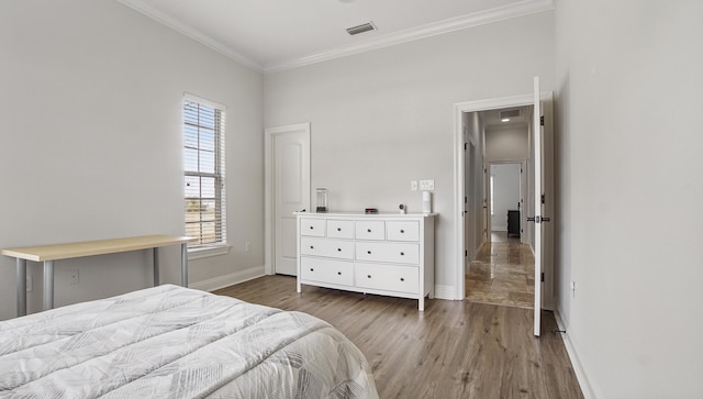 bedroom with dark hardwood / wood-style flooring and ornamental molding