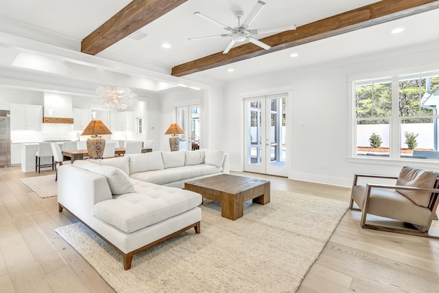 living room with beam ceiling, french doors, ceiling fan with notable chandelier, and light wood-type flooring