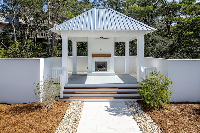 wooden deck featuring an outdoor fireplace and a gazebo