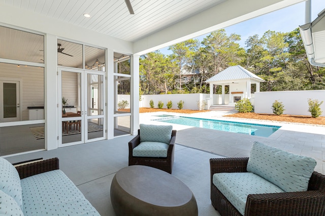 view of pool featuring a patio area, a sunroom, and ceiling fan