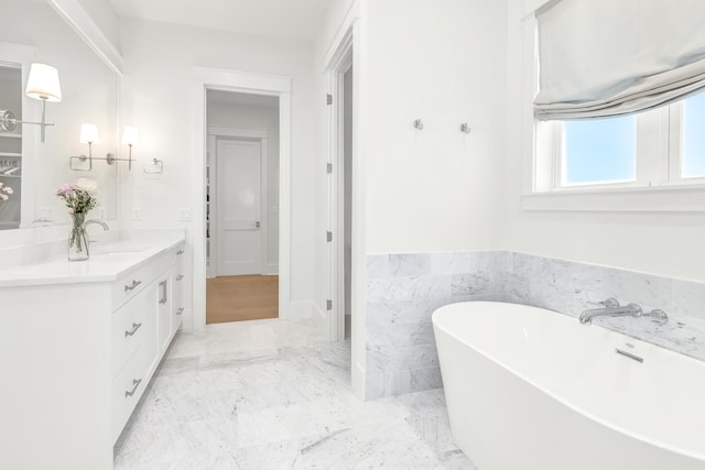 bathroom with vanity, tile walls, and a bathtub