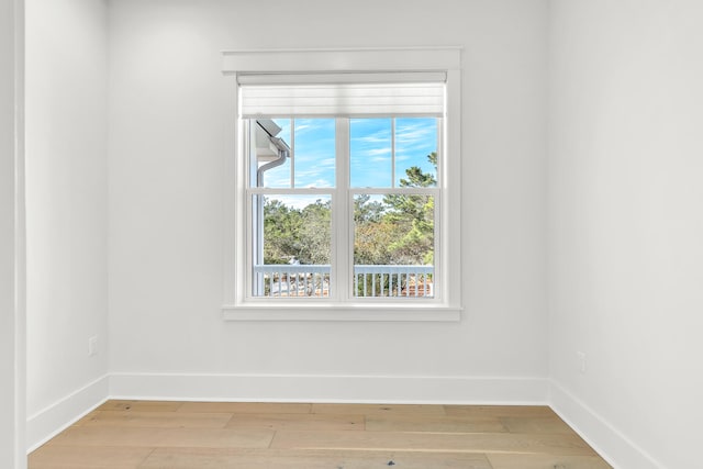 spare room featuring a wealth of natural light and hardwood / wood-style flooring