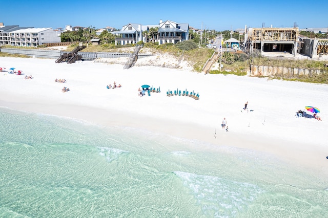 birds eye view of property with a water view and a beach view