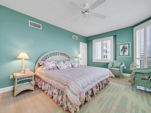 bedroom featuring multiple windows, visible vents, and wood finished floors