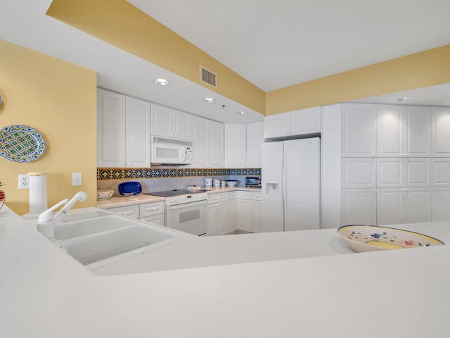 kitchen with white appliances, a sink, visible vents, white cabinetry, and light countertops