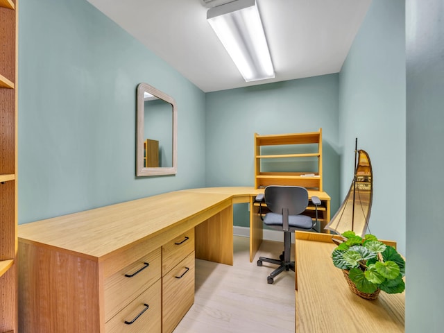 office space with built in desk and wood finished floors