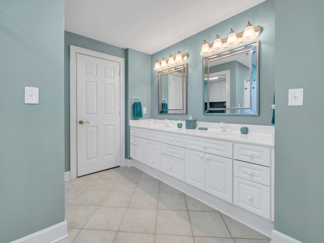 full bathroom with double vanity, tile patterned flooring, baseboards, and a sink