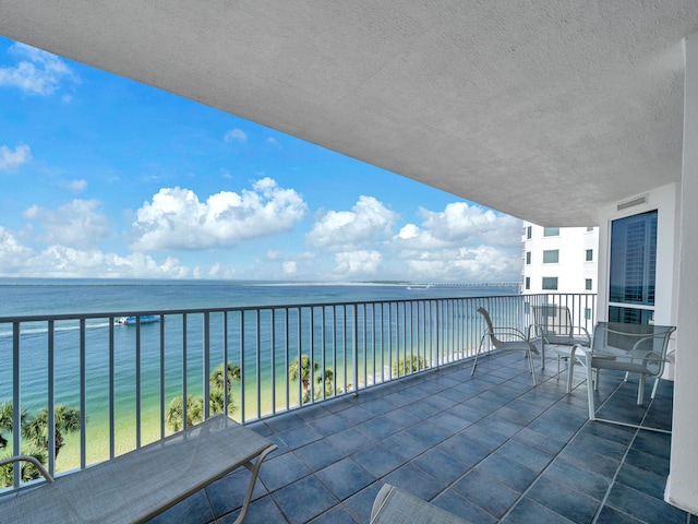 balcony featuring a water view and visible vents