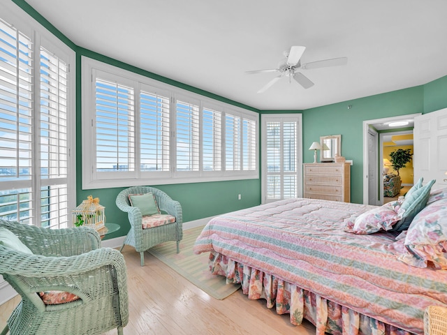 bedroom featuring ceiling fan, baseboards, and wood finished floors