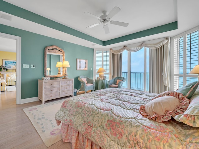 bedroom featuring visible vents, baseboards, a ceiling fan, wood finished floors, and access to outside