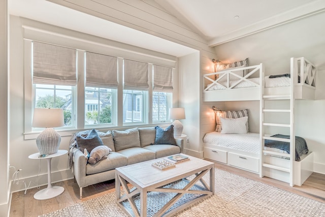 bedroom featuring lofted ceiling, hardwood / wood-style floors, and multiple windows