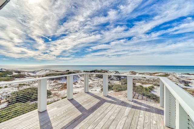 wooden terrace featuring a water view and a view of the beach