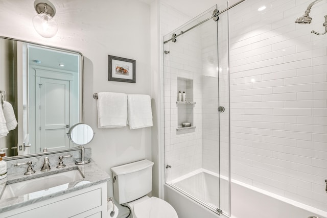 full bathroom featuring vanity, shower / bath combination with glass door, and toilet