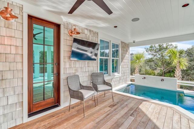 view of pool featuring a wooden deck and ceiling fan