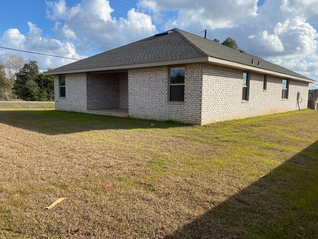 view of side of home with a lawn