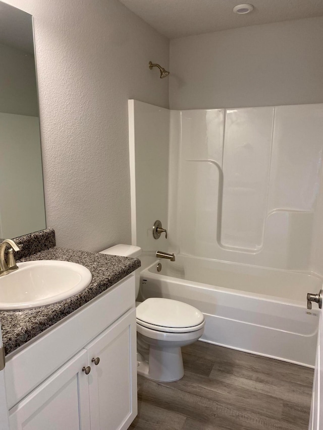 full bathroom with vanity, wood-type flooring, toilet, and tub / shower combination