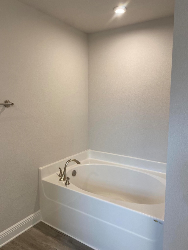 bathroom featuring hardwood / wood-style flooring and a washtub