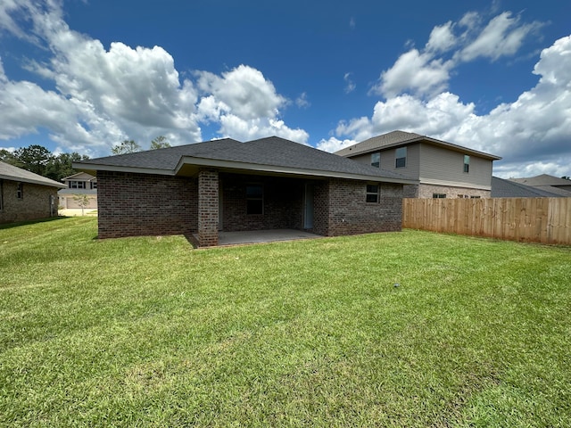 back of house with a patio and a lawn