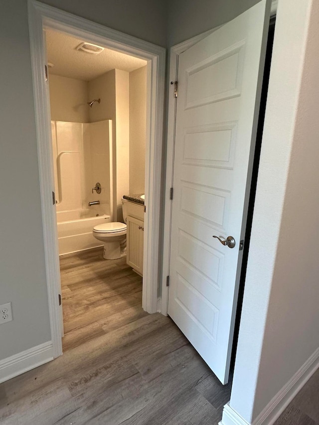 full bathroom with vanity, hardwood / wood-style flooring, toilet, and tub / shower combination