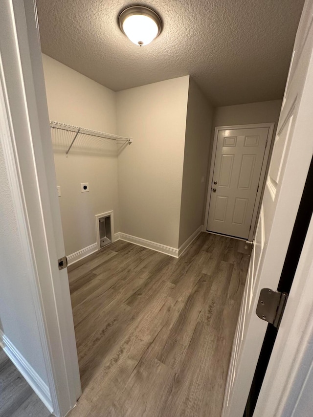 clothes washing area featuring hookup for an electric dryer, hardwood / wood-style floors, and a textured ceiling