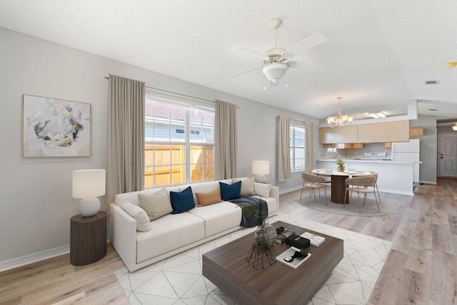 living room featuring a textured ceiling, light hardwood / wood-style flooring, and ceiling fan with notable chandelier