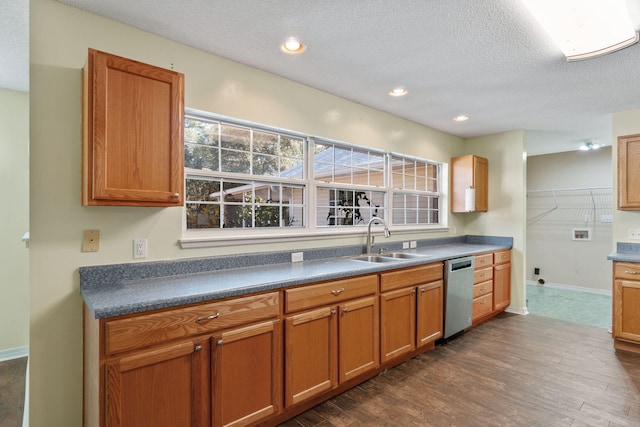 kitchen featuring a textured ceiling, sink, stainless steel dishwasher, and dark hardwood / wood-style flooring