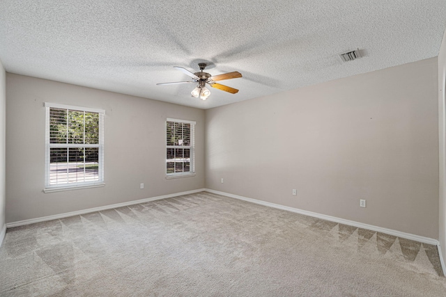 unfurnished room featuring ceiling fan, a textured ceiling, and light colored carpet