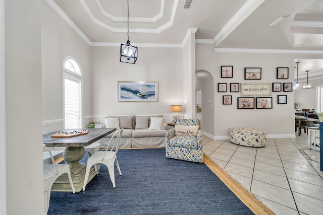 living room with ornamental molding, a notable chandelier, and tile patterned flooring