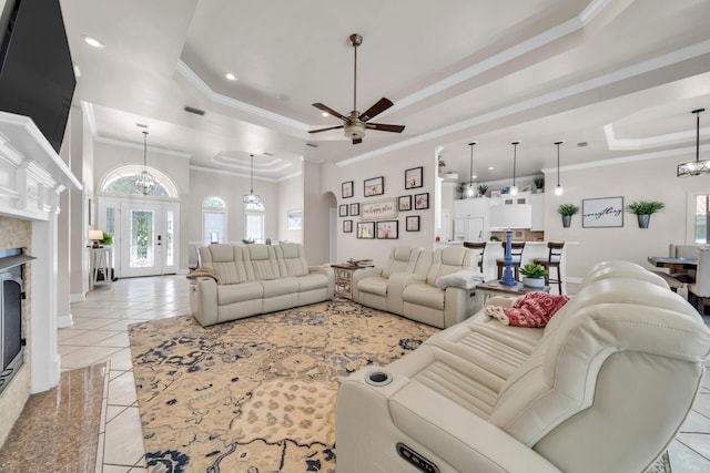 living room with ornamental molding, light tile patterned floors, and a raised ceiling