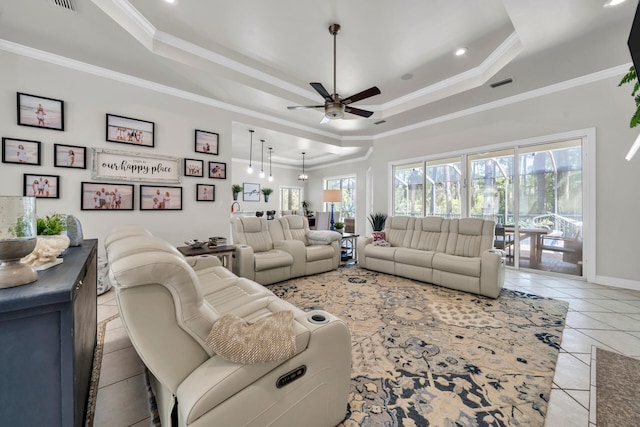 living room with crown molding, ceiling fan, light tile patterned floors, and a raised ceiling