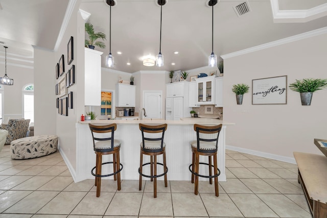 kitchen with white cabinets, kitchen peninsula, decorative light fixtures, and tasteful backsplash