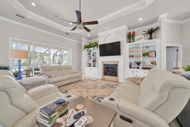 living room featuring ornamental molding, a tray ceiling, and ceiling fan