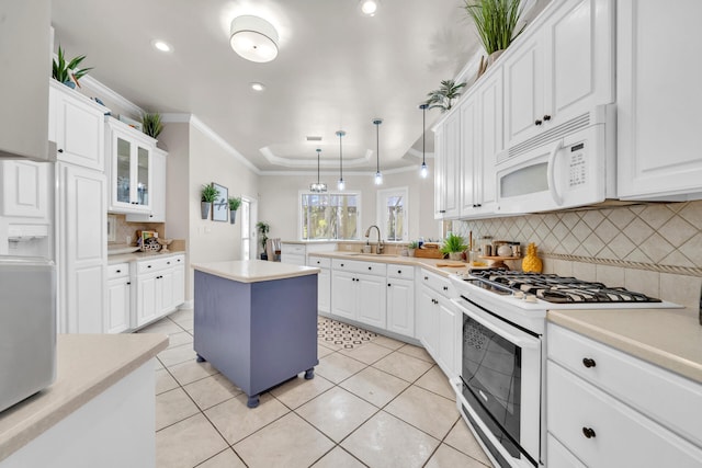 kitchen featuring white appliances, tasteful backsplash, a center island, pendant lighting, and white cabinets