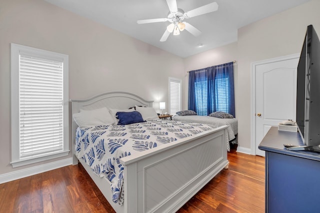 bedroom with multiple windows, dark hardwood / wood-style floors, and ceiling fan