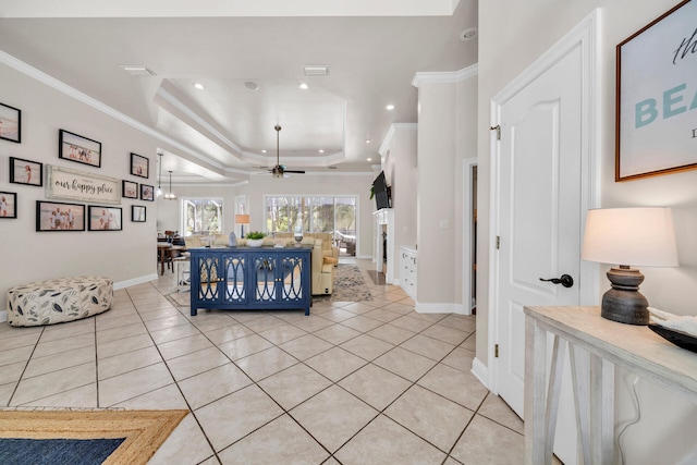 living room with ornamental molding, light tile patterned flooring, a raised ceiling, and ceiling fan