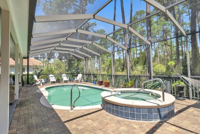 view of pool with an in ground hot tub, a patio, and glass enclosure