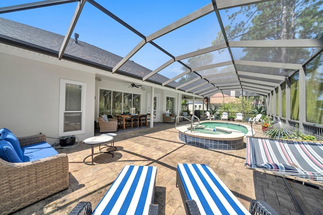 exterior space with ceiling fan, an in ground hot tub, and glass enclosure